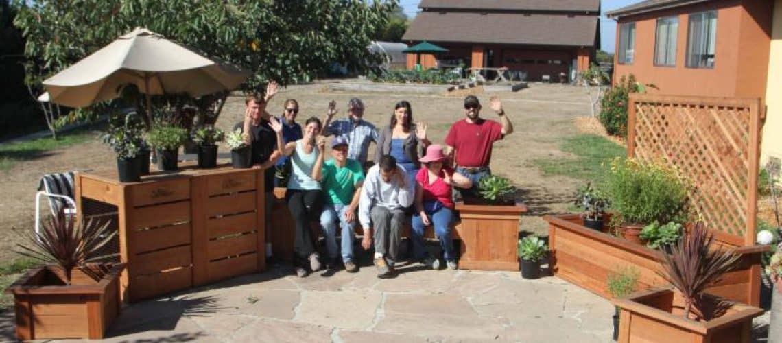 members of Camphill Communities California stand outdoors with redwood garden planters